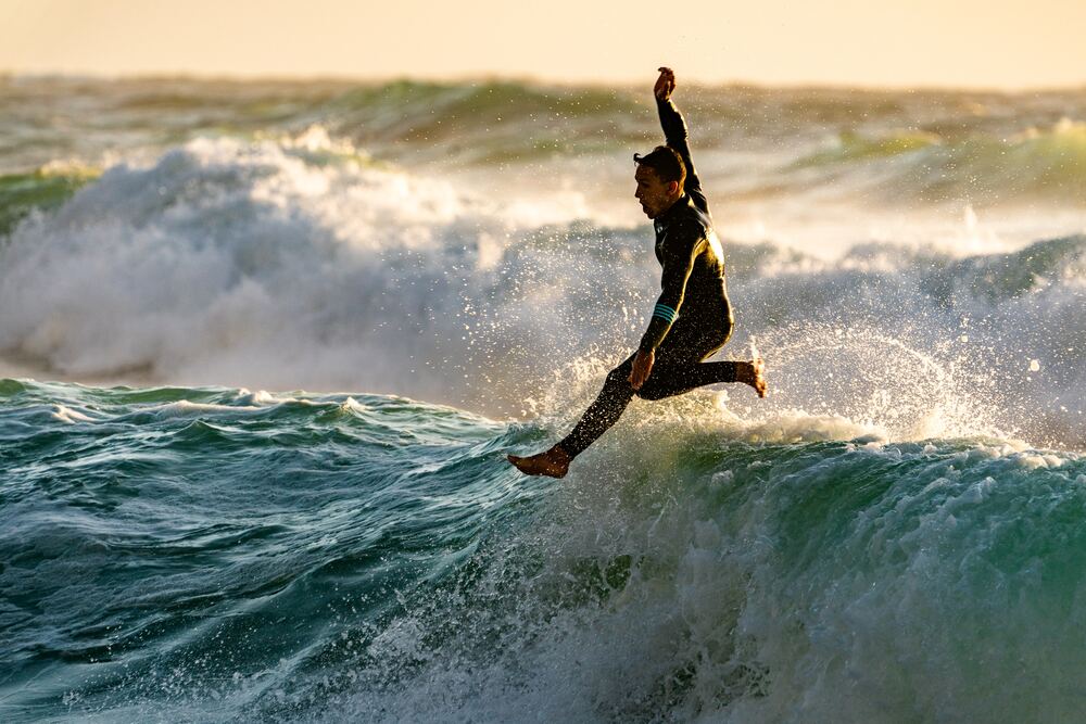 Surfer cayendo de la tabla al tomar una ola