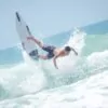 Surfer cayendo de la tabla al tomar una ola